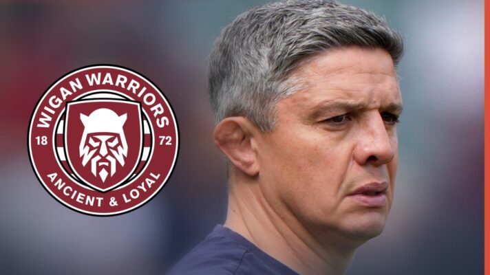 Paul Deacon next to the Wigan Warriors badge