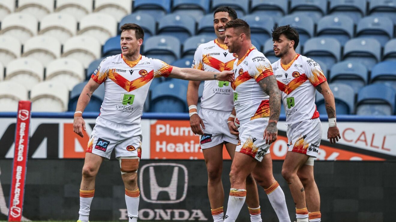 Tariq Sims celebrates a try with his Catalans Dragons team-mates in 2025
