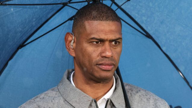 A close-up shot of Leon Pryce underneath an umbrella working as a pundit at a Super League game in 2025