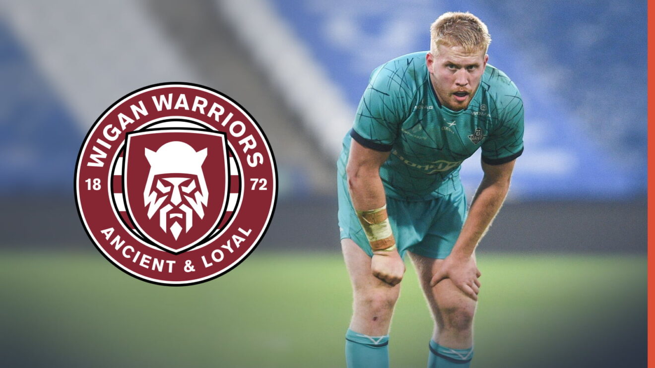 Oliver Wilson in action for Huddersfield Giants in 2025, stood to the right of a Wigan Warriors badge imposed into the picture