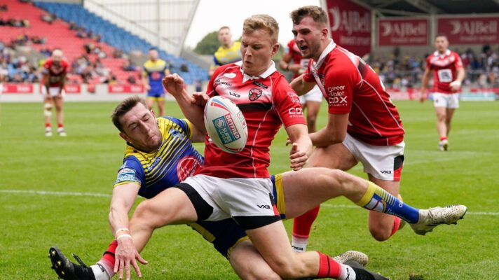 Salford Red Devils' Myles Harrop guards the ball from Warrington Wolves' Jake Wardle during a Super League clash in 2022
