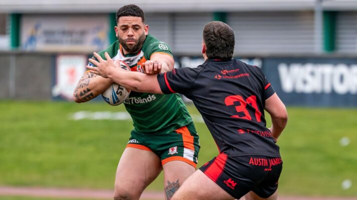 Kevin Larroyer in action for Hunslet in 2025, fending off a Widnes Vikings defender with the ball in hand