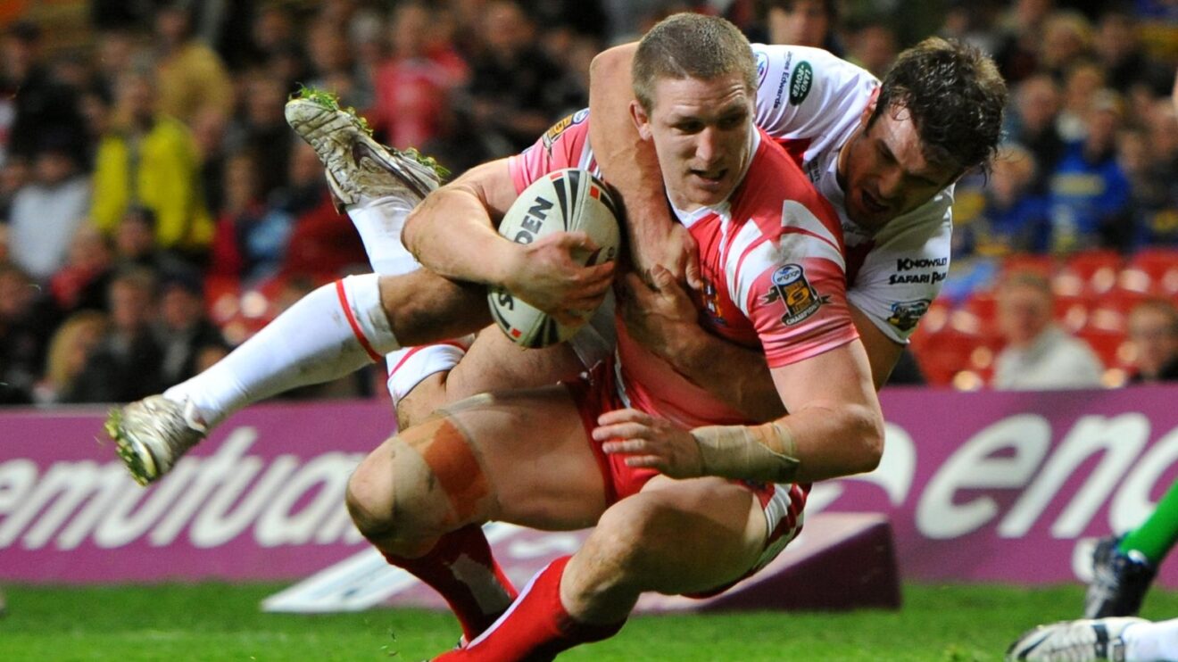 Ryan Hoffman dives for the line to score for Wigan Warriors against St Helens at Magic Weekend in 2011, with Scott Moore failing in his attempts to stop the try