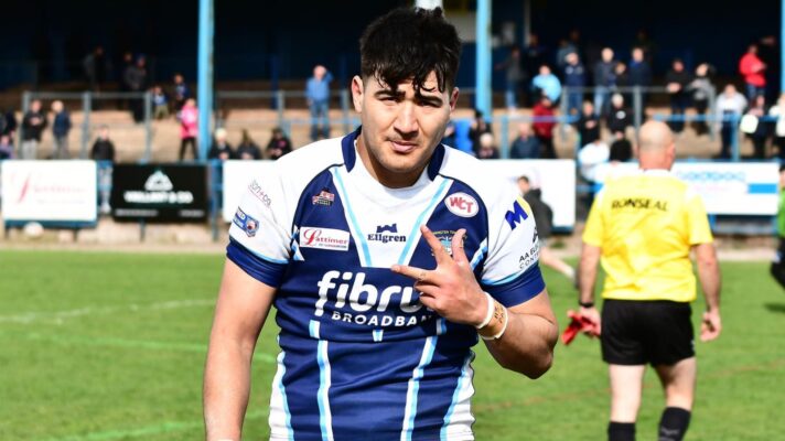 Levi Atiga shows three fingers to the camera after scoring a hat-trick for Workington Town in 2025