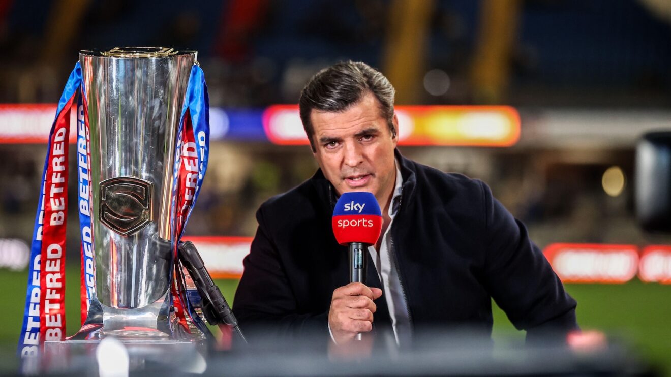 Brian Carney presents a Super League game for Sky Sports with the Super League trophy beside him