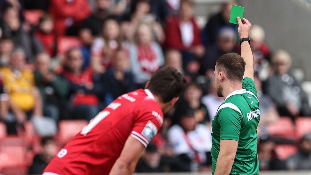 Referee Tom Grant shows a green card to a player during a Super League game