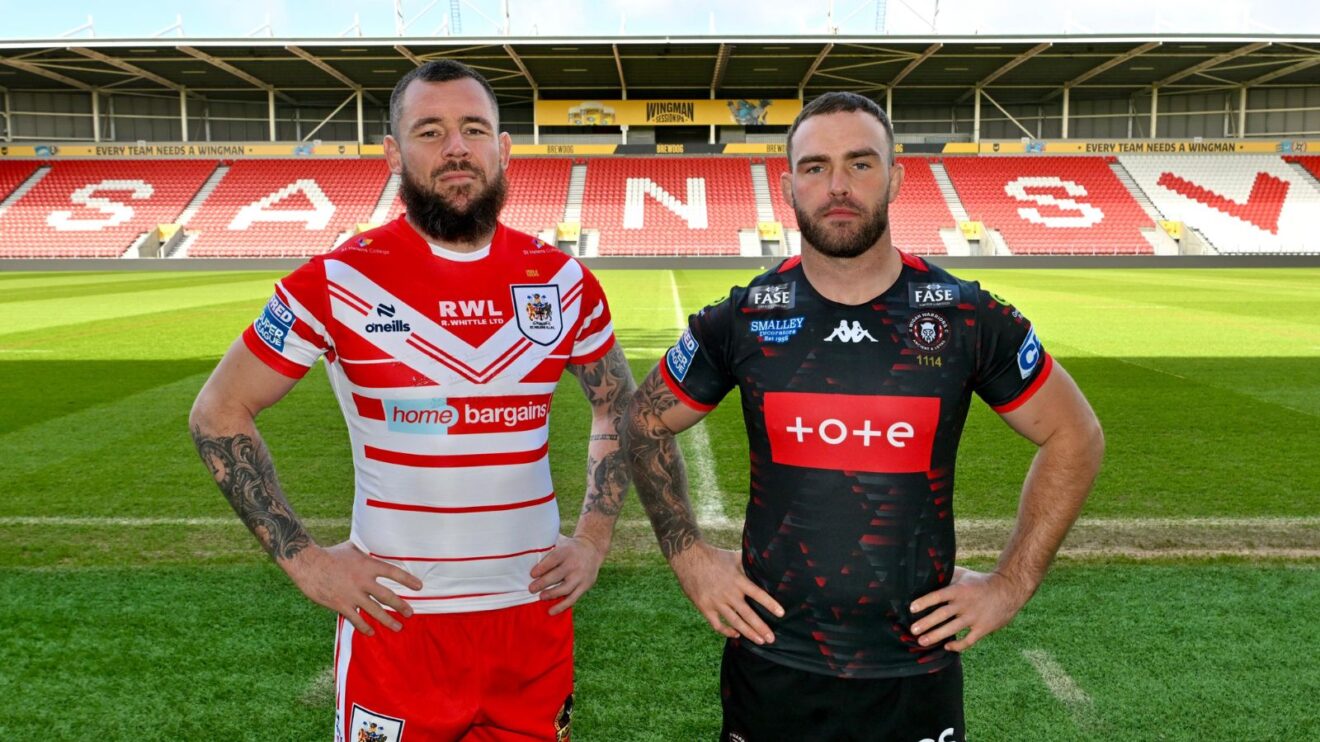 St Helens' David Klemmer and Wigan Warriors' Kaide Ellis pose facing the camera at the BrewDog Stadium in a promotional shot for the 2026 instalment of the Good Friday derby