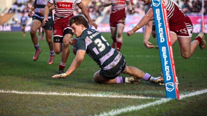 Jacob Douglas slides in to score a try for Huddersfield Giants against Wigan Warriors in 2026