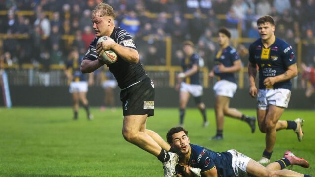 Sam Grice in action for Castleford Tigers during a pre-season clash against Leeds in 2026, breaking the tackle of a Rhinos player