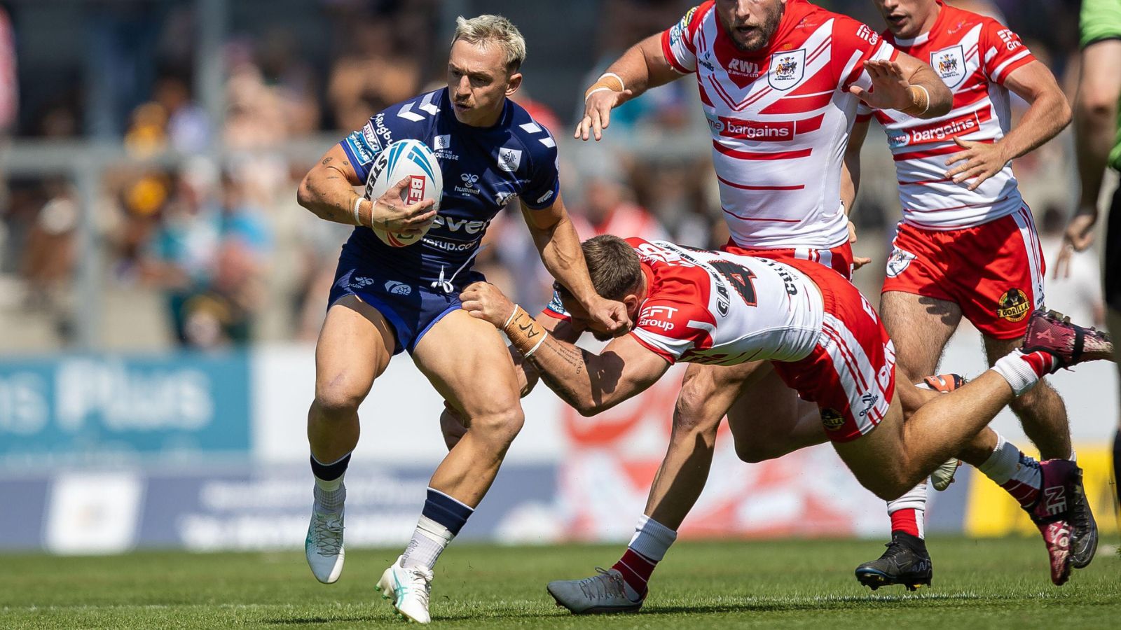 Olly Ashall-Bott in action for Toulouse Olympique in 2026, attempting to evade the grasp of a St Helens player